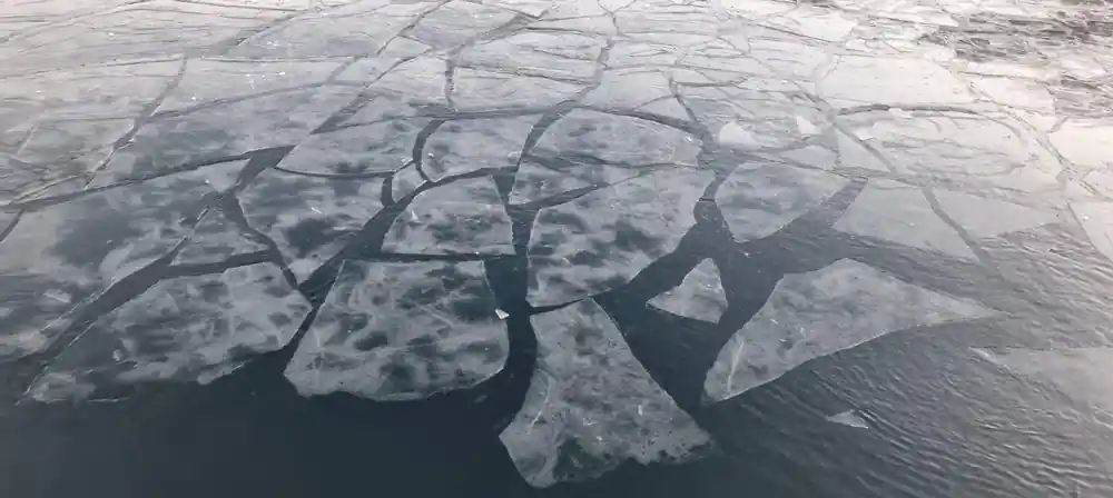 Aerial view of glacial river delta patterns on ice