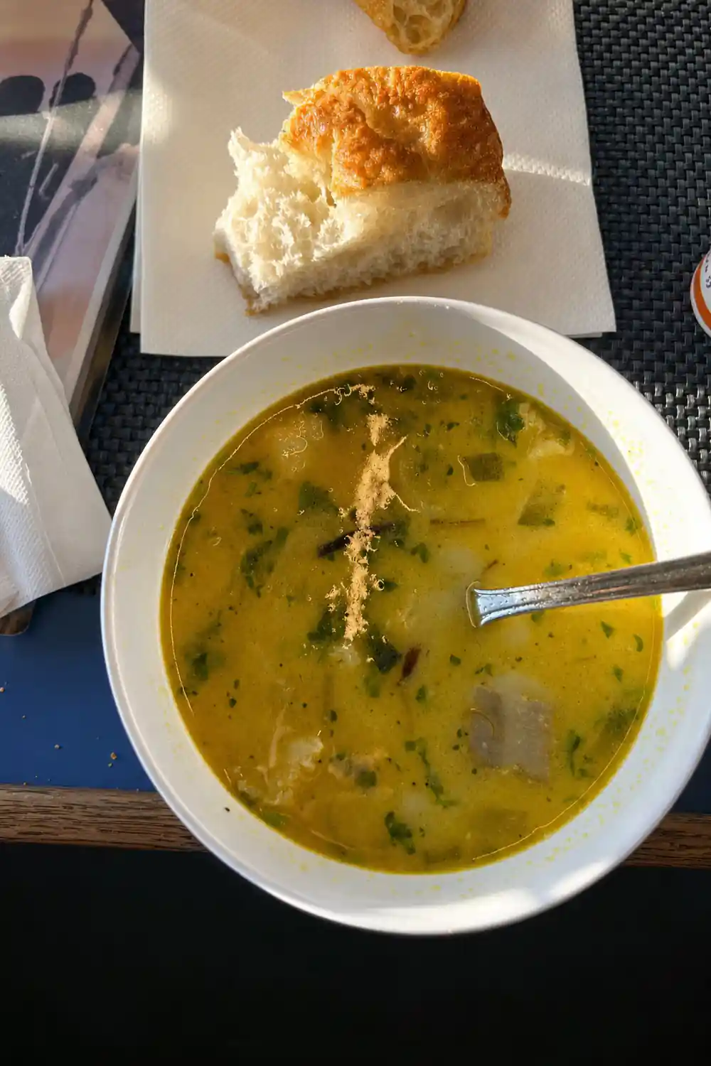Bowl of soup with bread roll on boat table
