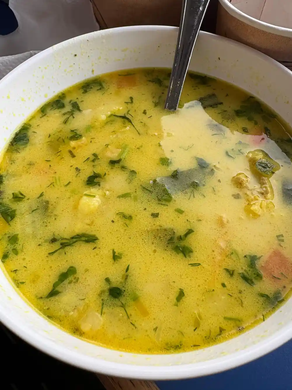 Bowl of soup with herbs and seafood chunks