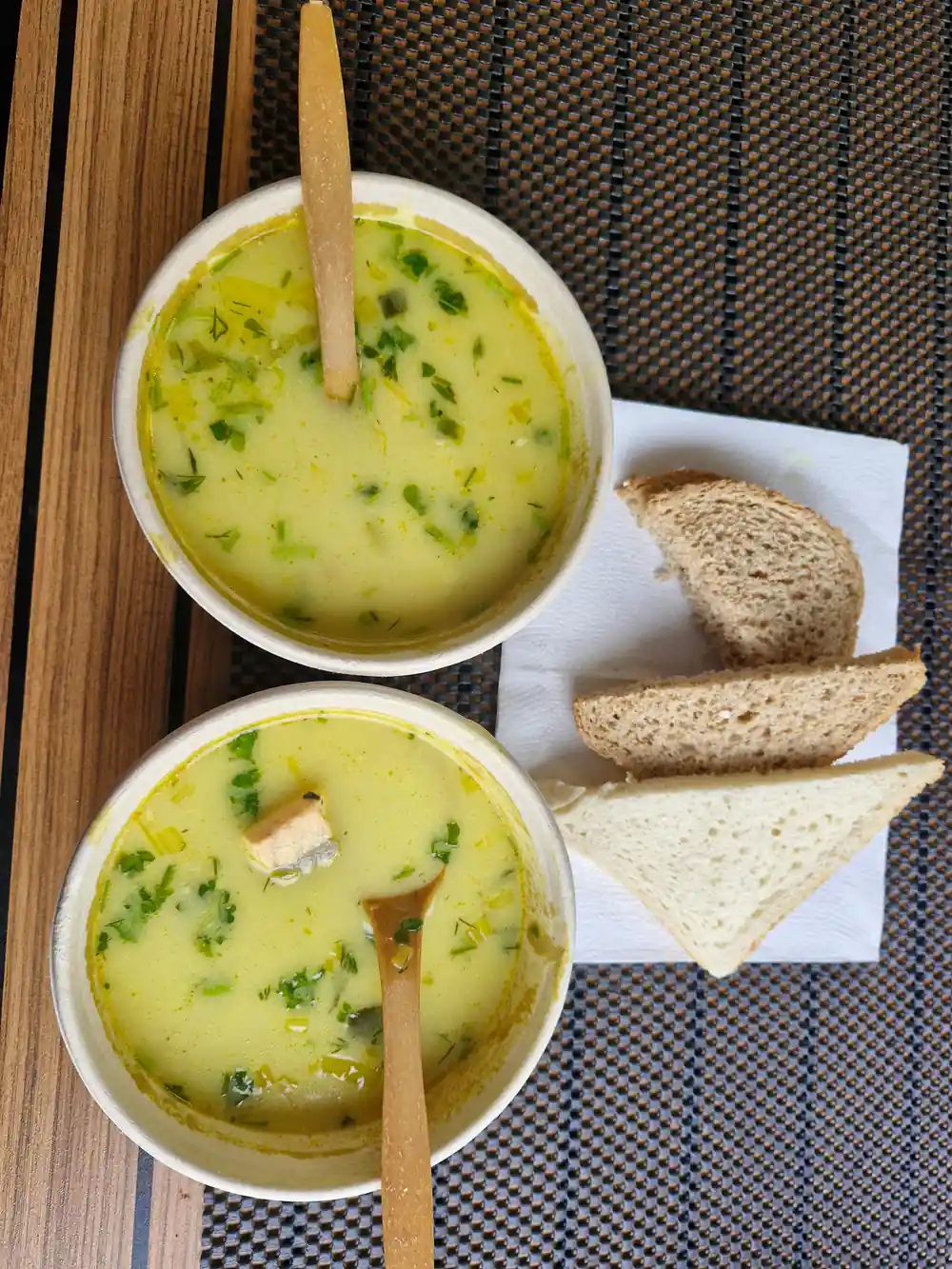 Green soup with bread and wooden spoon overhead